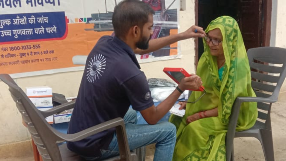 A VisionSpring worker fits new glasses for a carpet weaver at an eye screening camp in India. Photo credit: GoodWeave Certification Private Limited 