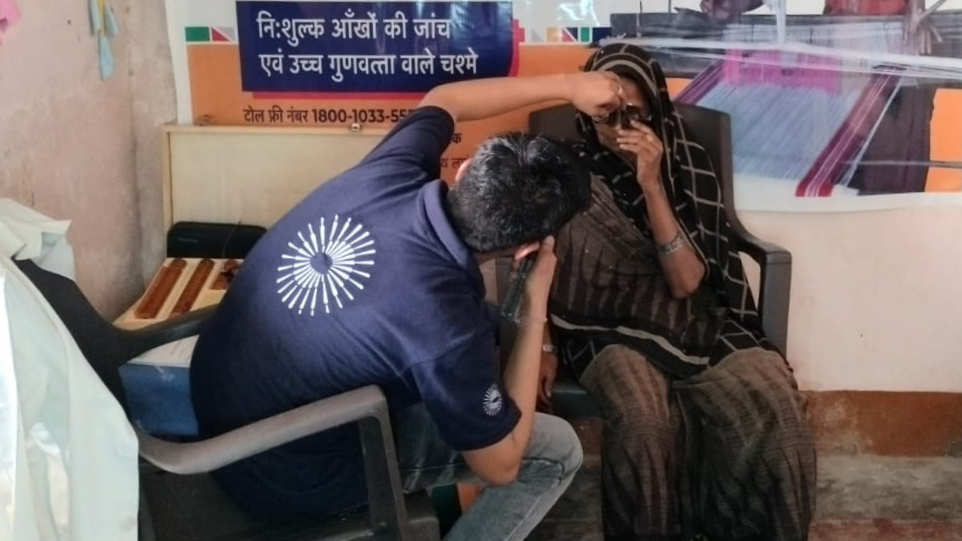 A VisionSpring worker conducts an eye examination for a carpet weaver at an eye screening camp. Photo credit: GoodWeave Certification Private Limited