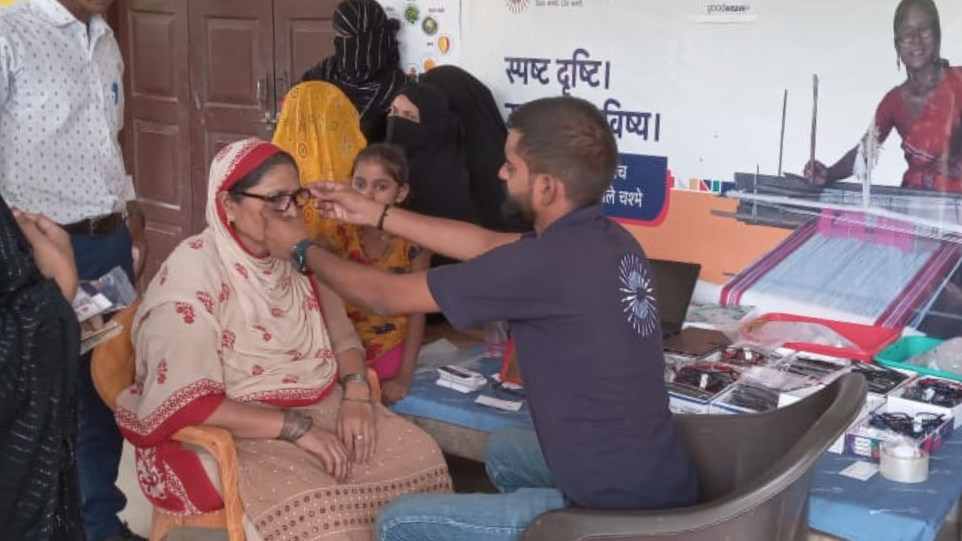 Photo caption: A VisionSpring worker fits new glasses for a carpet weaver at an eye screening camp in India. Photo credit: GoodWeave Certification Private Limited